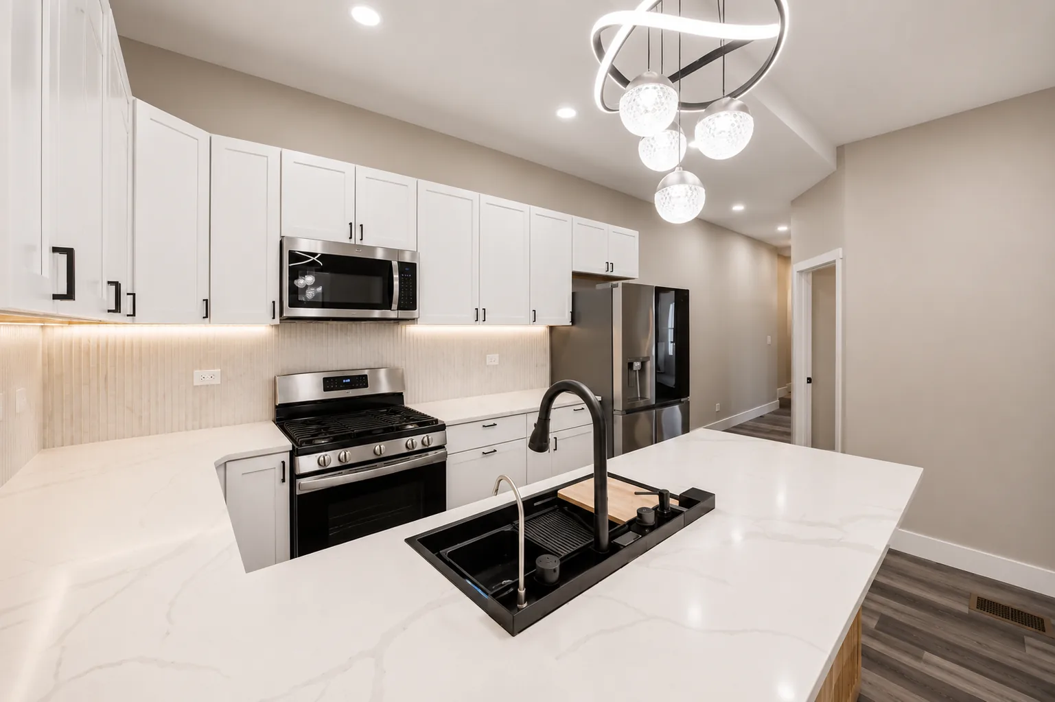 The same kitchen from the island, looking along the run of cabinets to the range