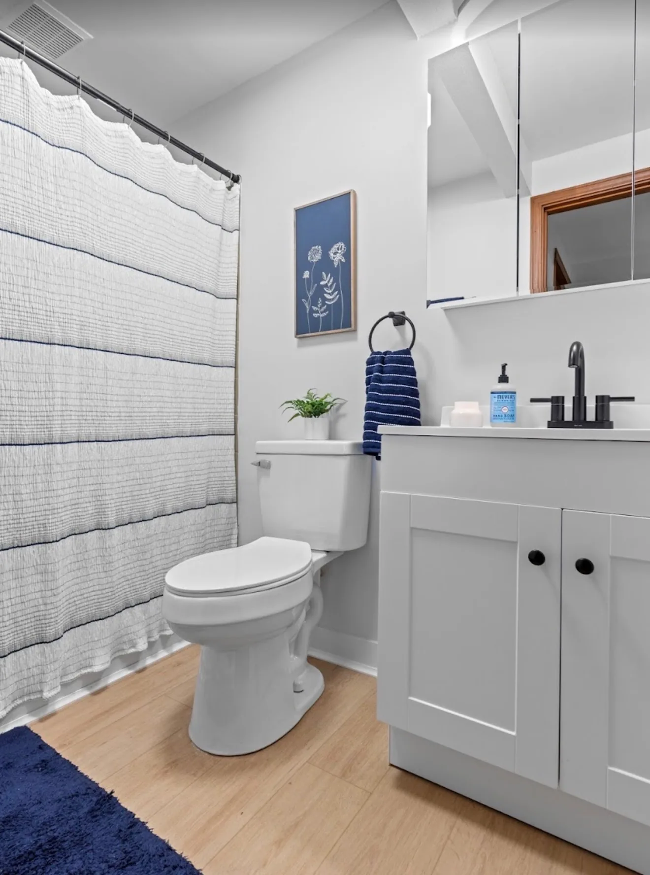 A renovated apartment bathroom at Remington with a white shaker vanity and matte black fittings